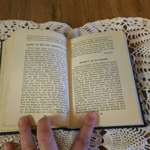 May include: An open book with the title "Practical English for Writing and Reading" on the cover. The book is open to a page with the heading "Majesty in Plainness" and text about the clarity of speech.