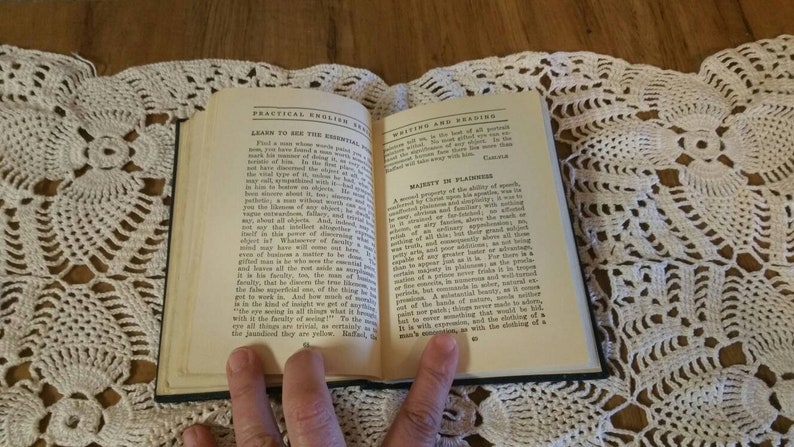May include: An open book with the title "Practical English for Writing and Reading" on the cover. The book is open to a page with the heading "Majesty in Plainness" and text about the clarity of speech.
