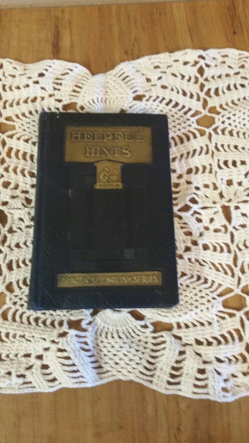 May include: A black book with gold lettering on the cover. The title is "Helpful Hints" and the subtitle is "Practical English Series".