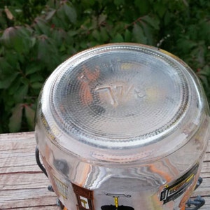 May include: Clear glass jar with a 7 1/2 printed on the bottom. The jar has a colorful design around the sides.