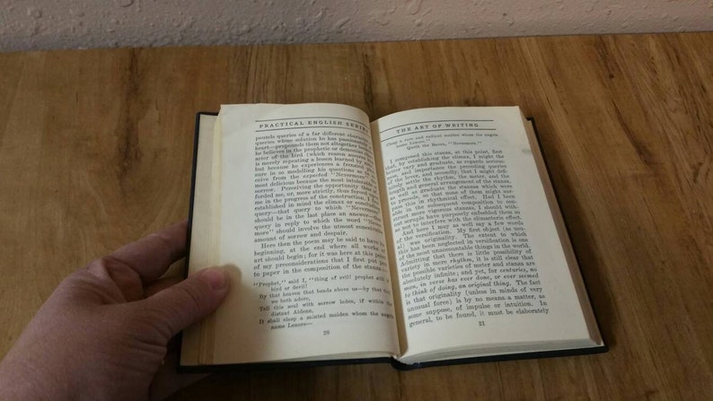 May include: An open book with the title "Practical English" on the left page and "The Art of Writing" on the right page. The book is open to page 22 and the text is visible on both pages.