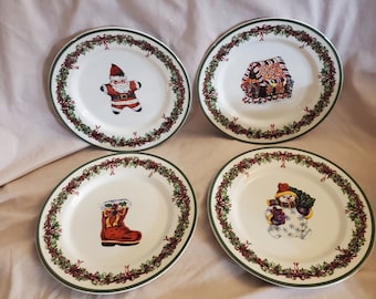 May include: Set of four white ceramic Christmas plates with green and red trim. Each plate features a different Christmas image: Santa Claus, a gingerbread house, a stocking, and a snowman.