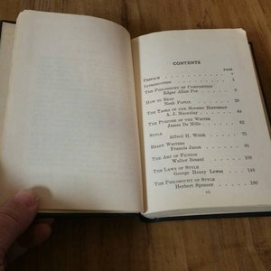 May include: A book with a white cover and black text. The book's title is "The Philosophy of Style" by Herbert Spencer. The table of contents lists the names of authors and their essays, including "The Philosophy of Composition" by Edgar Allan Poe, "How to Tell a Story" by Mark Twain, and "The Art of Fiction" by Henry James.
