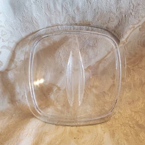 Può includere: Coperchio in vetro trasparente per una pirofila quadrata. Il coperchio ha un piccolo pomo al centro.