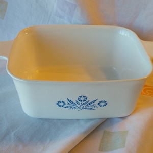 Puede incluir: Plato para hornear cuadrado blanco con diseño floral azul. El plato tiene dos asas a los lados.