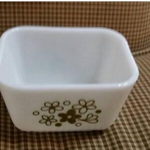 Op de afbeelding: Witte vierkante bakvorm van keramiek met een bruin bloemenmotief.