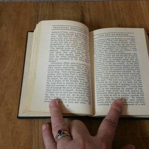May include: An open book with the title "Practical English Grammar" on the left page and "The Art of Writing" on the right page. The book is open to a page discussing the importance of writing and the use of language.