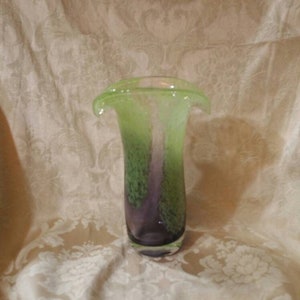 May include: A green and purple glass vase with a wide, flared opening. The vase has a mottled, textured surface.