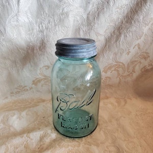 May include: A vintage green glass Ball Perfect Mason jar with a silver lid.