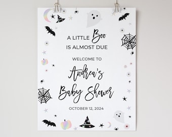 May include: White Halloween-themed baby shower sign with the text "A Little Boo Is Almost Due" and "Andrea's Baby Shower" with the date October 12, 2024. The sign is decorated with bats, ghosts, spiderwebs, and stars.