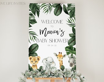 May include: A rectangular welcome sign for a baby shower featuring the text "WELCOME TO Monica's BABY SHOWER 09.24.22". The design includes watercolor illustrations of a lion cub, elephant, giraffe, and zebra surrounded by dark green tropical leaves.