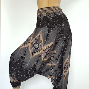 May include: Black harem pants with a white and brown geometric pattern. The pants have a wide leg and a drawstring waist.