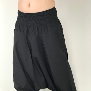 May include: Black cotton harem pants with a wide, elastic waistband and a loose, flowing fit.