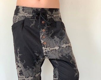 May include: Black and grey tie-dye cropped trousers with a button fly and a drawstring waist.