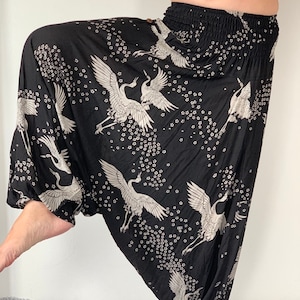 May include: Black harem pants with a white crane and flower pattern.