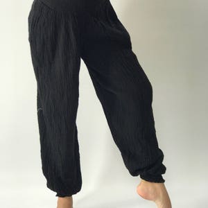 May include: Black cotton pants with a wide leg and elastic waistband.