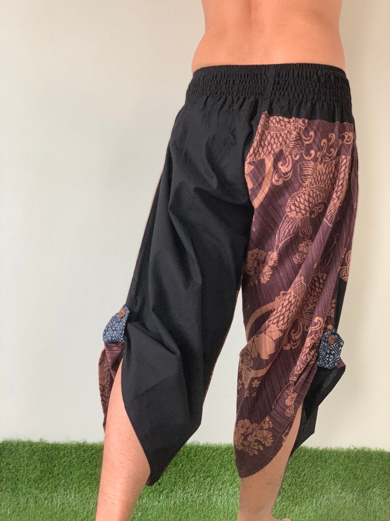 May include: Black and brown pants with a patterned design featuring a fish and floral motifs. The pants have an elastic waistband and a loose fit.