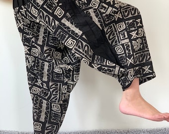 May include: Black and white patterned pants with a wide, elastic waistband. The pants have a loose, flowing fit and a geometric design.