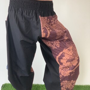 May include: Black and brown patterned pants with an elastic waistband. The pants have a fish design on one leg.