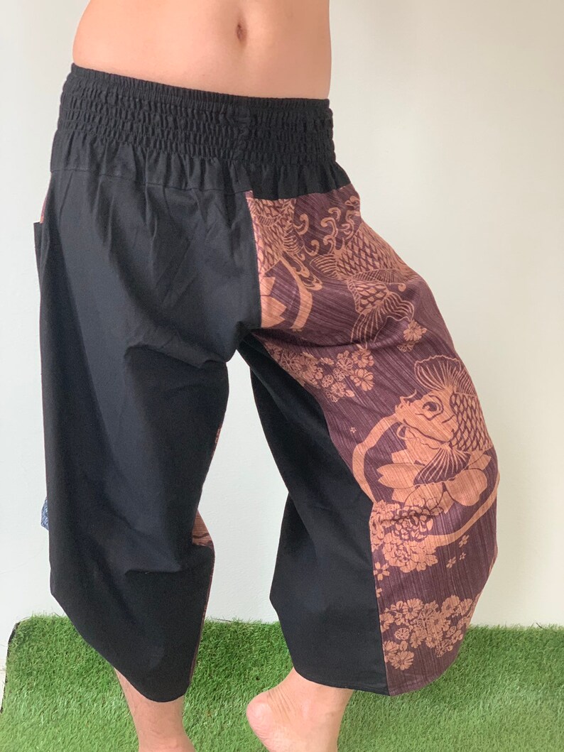 May include: Black and brown patterned pants with an elastic waistband. The pants have a fish design on one leg.