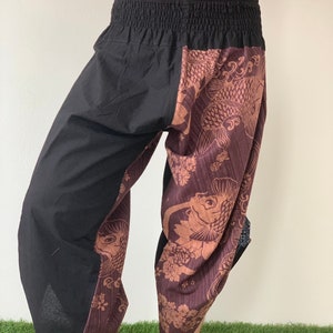 May include: Black and brown patterned pants with an elastic waistband. The pants have a fish design on one leg and a solid black color on the other leg.