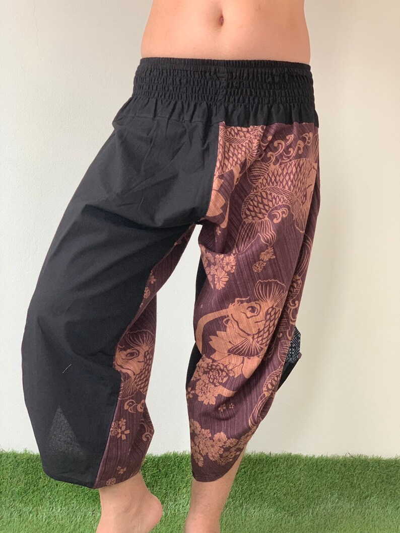 May include: Black and brown patterned pants with an elastic waistband. The pants have a fish design on one leg and a solid black color on the other leg.