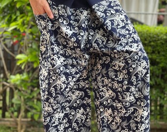 Può includere: Pantaloni a stampa onde bianco e nero con una cintura blu scuro e un nodo in vita.