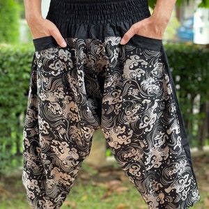 May include: Black and white patterned pants with a wide leg and an elastic waistband. The pattern features a repeating design of clouds and waves.