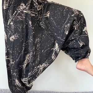 May include: Black and white printed loose-fitting pants with a drawstring waist.