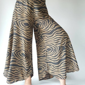 May include: Wide-leg pants with a brown and black zebra print. The pants have a high waist and a flowing silhouette.