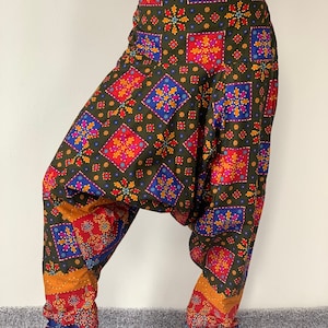 May include: Green, red, blue, and orange patterned pants with a loose, baggy fit. The pants have a geometric design with squares and flowers.