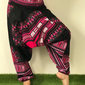 May include: Black and pink patterned pants with a wide leg and a loose fit. The pants have a geometric design with pink and white accents.