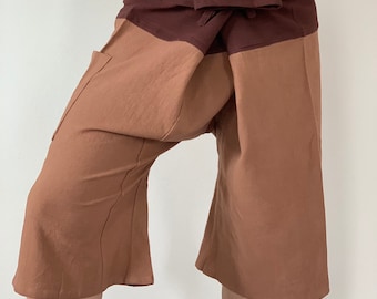 May include: Brown and tan cotton pants with a wide waistband that ties at the front. The pants have a loose, flowing fit and are perfect for warm weather.