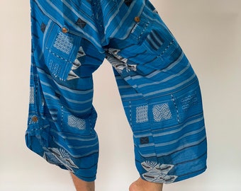 May include: Blue and white patterned trousers with a drawstring waist. The trousers have a loose, flowing fit and are made of a lightweight fabric.