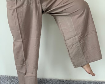 May include: A pair of light brown wide-leg pants with a wrap-around waist tie. The pants are made of a soft, lightweight fabric.