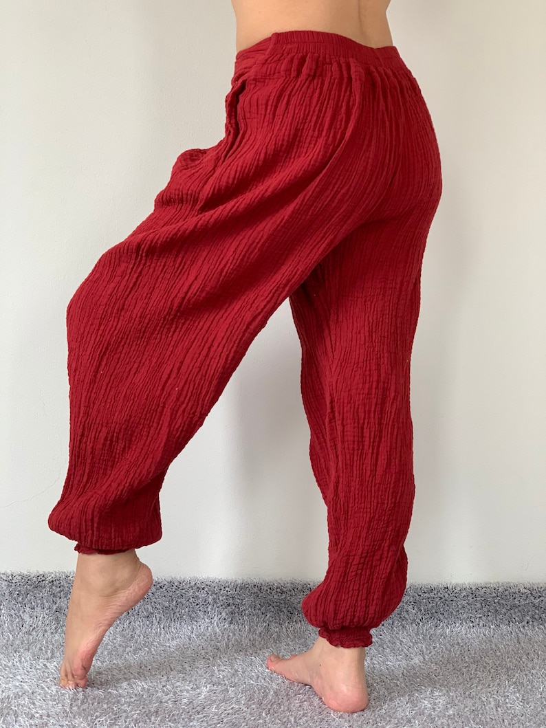 May include: Red cotton pants with a wide leg and elastic waistband. The pants are made of a soft, comfortable fabric and have a relaxed fit.