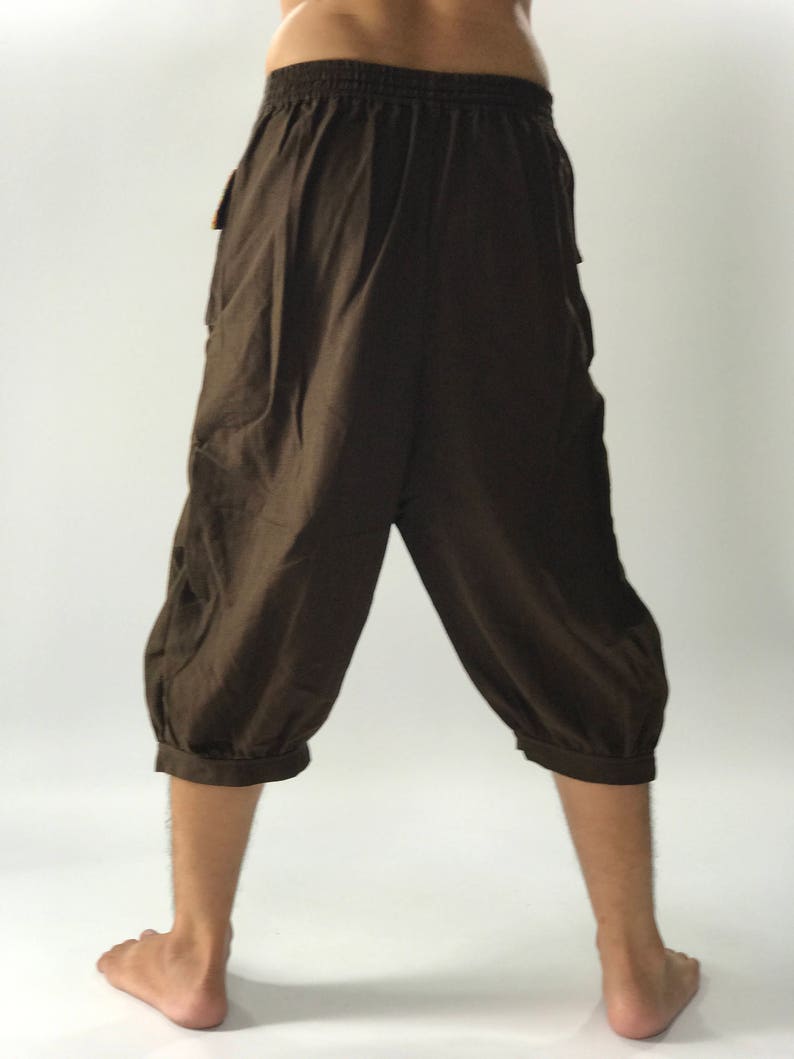 May include: Brown cotton pants with a drawstring waist and elastic cuffs. The pants are a relaxed fit and have a casual style.