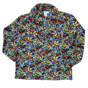 May include: A long-sleeved button-down shirt with a vibrant floral pattern. The shirt features a colorful design with blue, red, yellow, and black flowers. The collar is visible, and the shirt is made of a lightweight fabric.