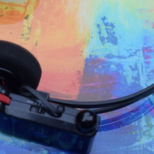 Pode incluir: Um tocador de cassetes Sony Walkman preto e vermelho com uma faixa de cabe&ccedil;a preta e um fone de ouvido preto. O tocador tem um bot&atilde;o prateado e o texto "AM/FM" &eacute; vis&iacute;vel no lado.