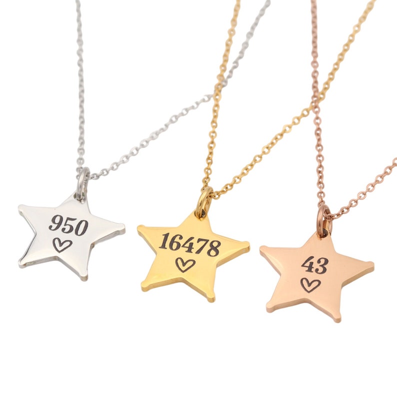 May include: Three silver, gold, and rose gold star necklaces with different numbers and a heart engraved on each star. The numbers are 950, 16478, and 43.