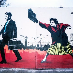 May include: A street art mural depicting two figures, one in a suit carrying a briefcase and the other throwing a shoe. The background features a cityscape with power lines and birds in flight. The text "Hop Jonie" is visible in the upper right corner.