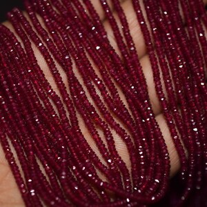 May include: Strands of faceted, deep red gemstones. The beads are small and uniform in size, creating a rich, textured appearance. The gemstones are likely rubies, and the overall effect is one of luxury and elegance. Ideal for jewelry making.