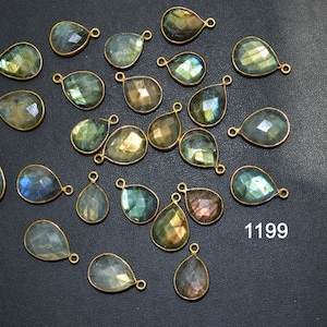 May include: A collection of 20 teardrop-shaped labradorite gemstone pendants with gold-tone jump rings. The stones are a mix of green, blue, and gray with iridescent flashes.