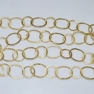 May include: A gold chain made of oval-shaped links. The chain is made of metal and has a textured finish.
