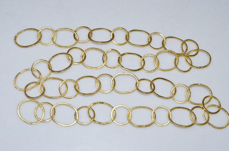 May include: A gold chain made of oval-shaped links. The chain is made of metal and has a textured finish.