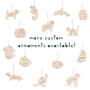 May include: A collection of wooden ornaments featuring various animal shapes, each with a personalized name. The ornaments are painted in natural wood tones and have a rustic charm. The text "more custom ornaments available!" is displayed in green letters.