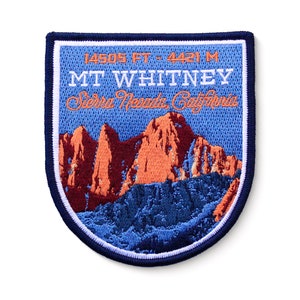 May include: Blue and white embroidered patch with a mountain range scene. The text reads "14505 FT - 4421 M MT WHITNEY Sierra Nevada California".