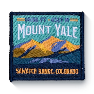 May include: Embroidered patch with a blue background and a mountain range scene. The text "Mount Yale" is in white with a teal background. The text "Sawatch Range, Colorado" is in white with a blue background. The text "14196 FT - 4327 M" is in white with a black background.