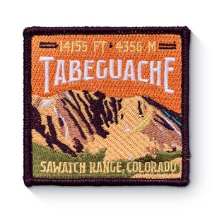 May include: An embroidered patch with a mountain scene and the text "14,155 FT. 4,356 M. TABEGUACHE SAWATCH RANGE, COLORADO".