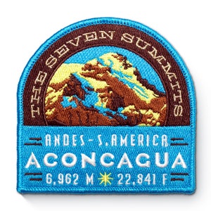 Może przedstawiać: Naszywka haftowana w kolorze niebieskim i brązowym z tekstem "The Seven Summits" i "Andes - S. America Aconcagua 6,962 M 22,841 F"